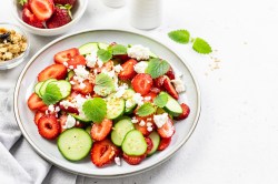 Erdbeer-Gurkensalat mit Feta in einer weißen Schüssel.