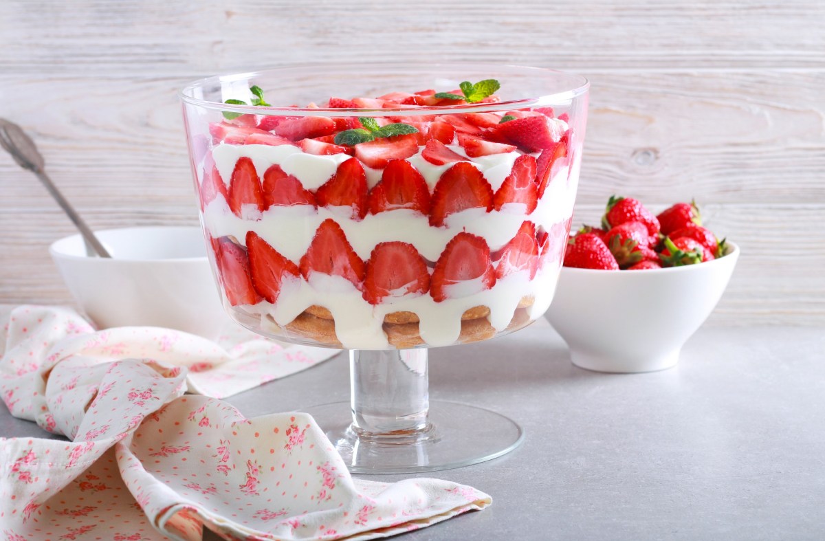 Ein Erdbeer-Trifle im Glasbehältnis auf einem Tisch.