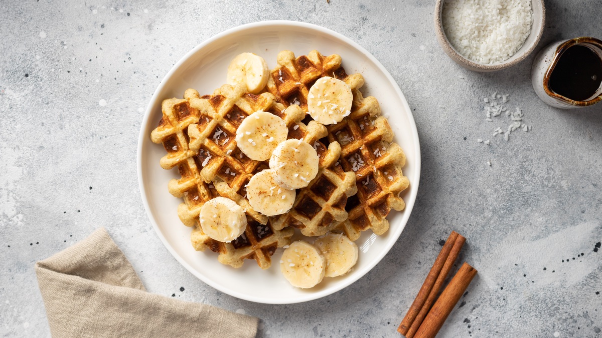 French-Toast-Waffeln auf weißem Teller mit Zimtstangen