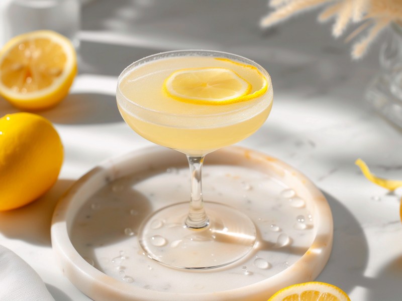 Glas Limoncello-Martini auf einem Tisch mit Zitronen