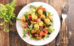 Ein Teller mit mediterranem Kartoffelsalat in der Draufsicht.