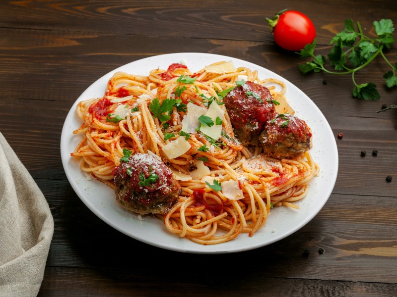 Spaghetti mit Fleischklößchen auf einem weißen Teller.