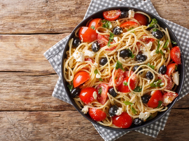 Spaghettisalat mit Feta und Tomaten in einer Schüssel.