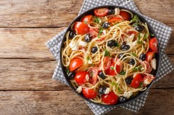 Spaghettisalat mit Feta und Tomaten in einer Schüssel.