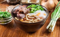 Eine Schüssel Udon-Nudelsuppe mit Ei und Rindfleisch.