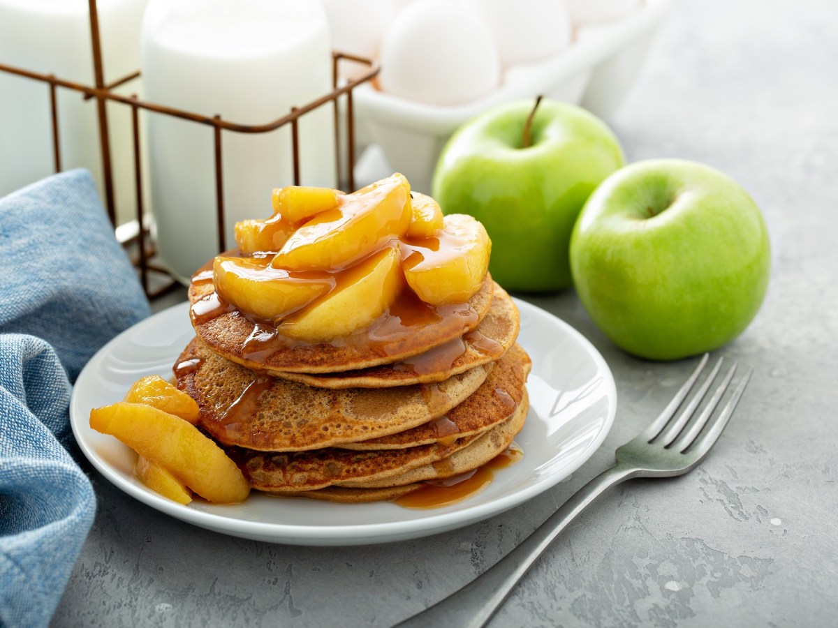 Teller mit Zwieback-Pancakes und Apfel-Topping, Gabel daneben