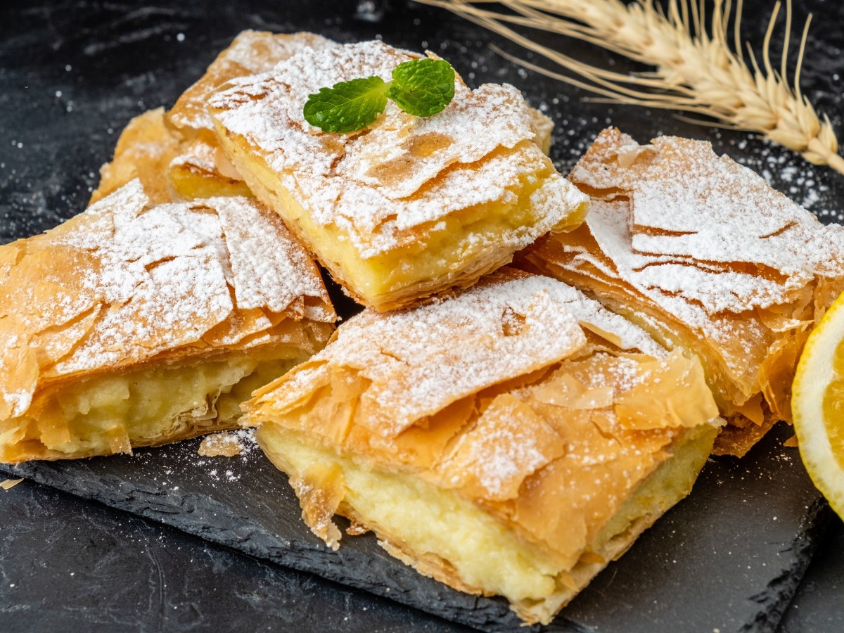 Einige Stücke Bougatsa serviert auf einer Schiefertafel.