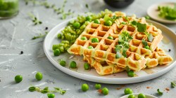 Erbsen-Waffeln auf einem weißen Teller mit Erbsen als Deko.