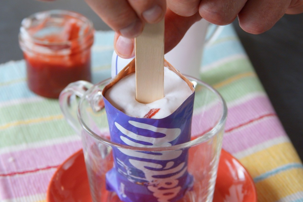 Ein Milka-Eis am Stiel in einer Schüssel, in das ein Holzstiel gesteckt wird.