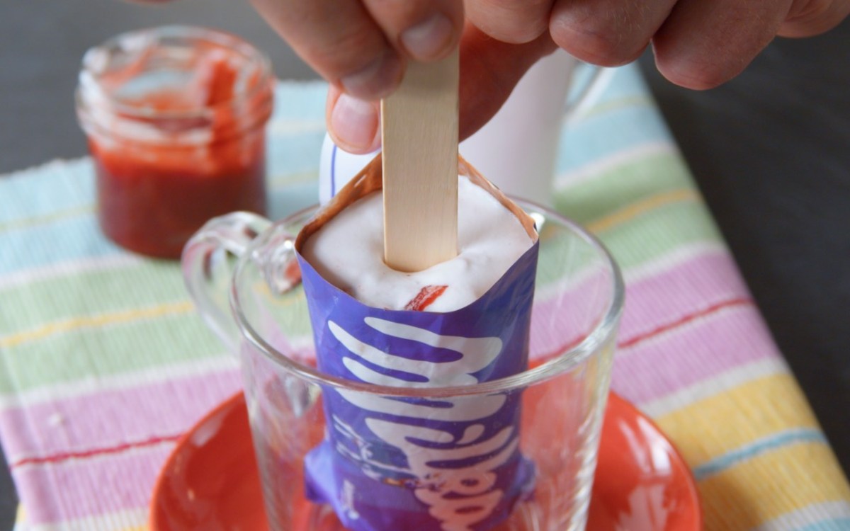 Ein Milka-Eis am Stiel in einer Schüssel, in das ein Holzstiel gesteckt wird.