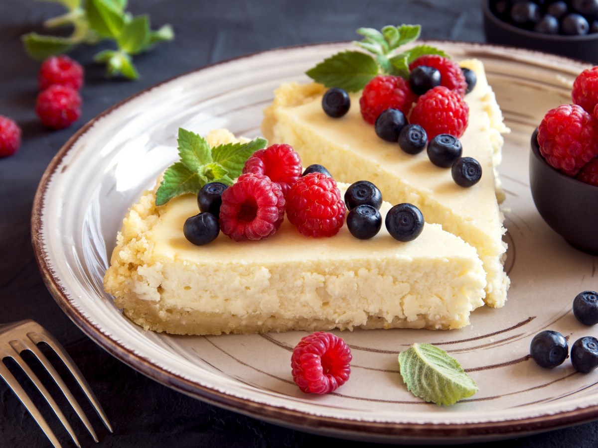 2 Stücke No-Bake-Kuchen auf einem Teller, garniert mit Beeren.