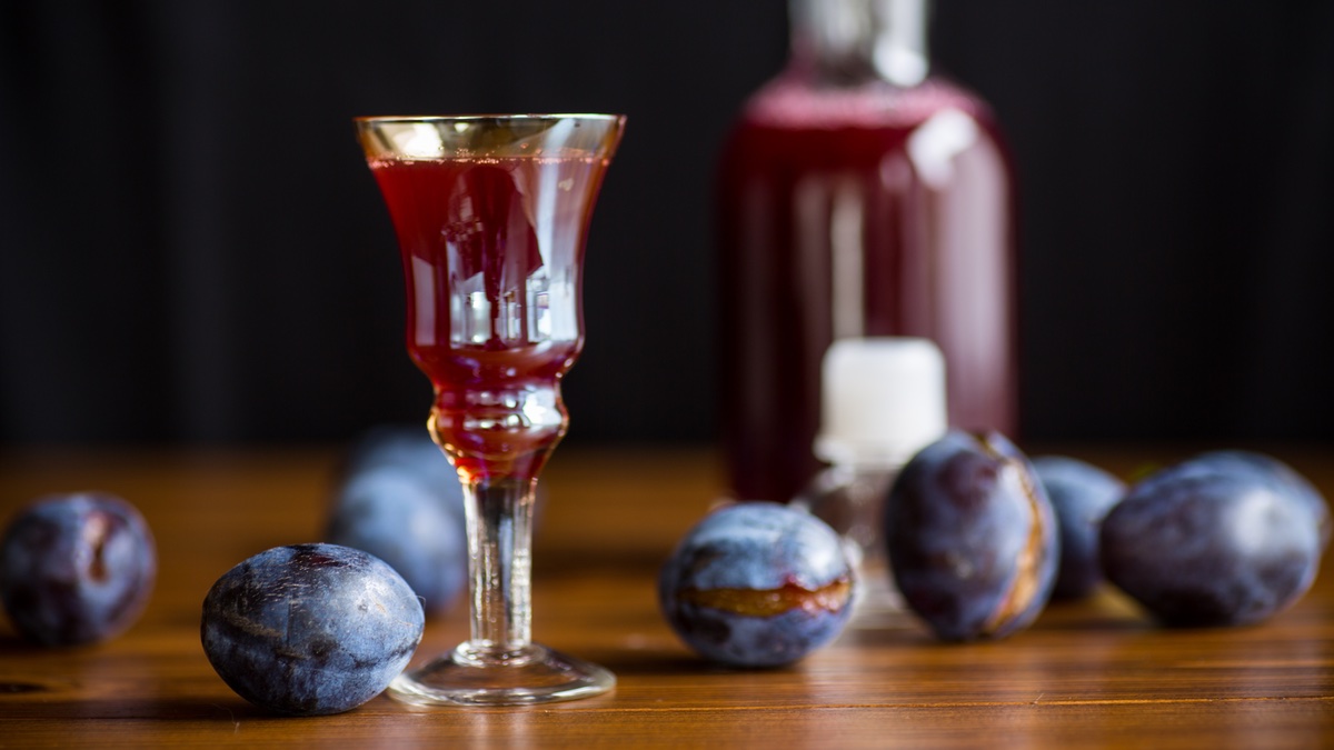 Pflaumenlikör in kleinem Glas auf dunklem Hintergrund.