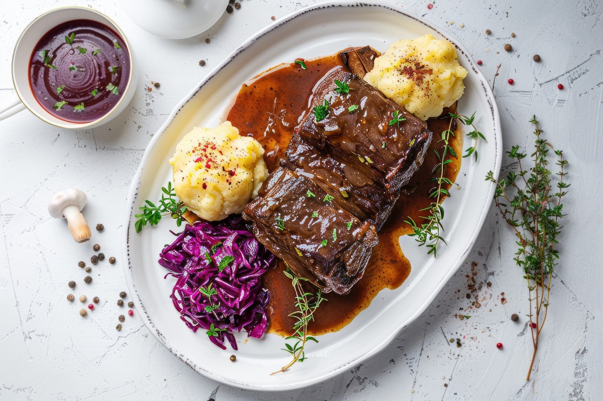 Teller mit Rheinischem Sauerbraten mit Kartoffelstampf und Rotkohl