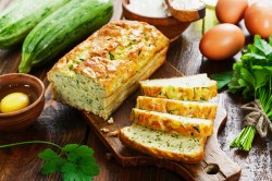 angeschnittenes Zucchini-Feta-Brot auf einem Brett