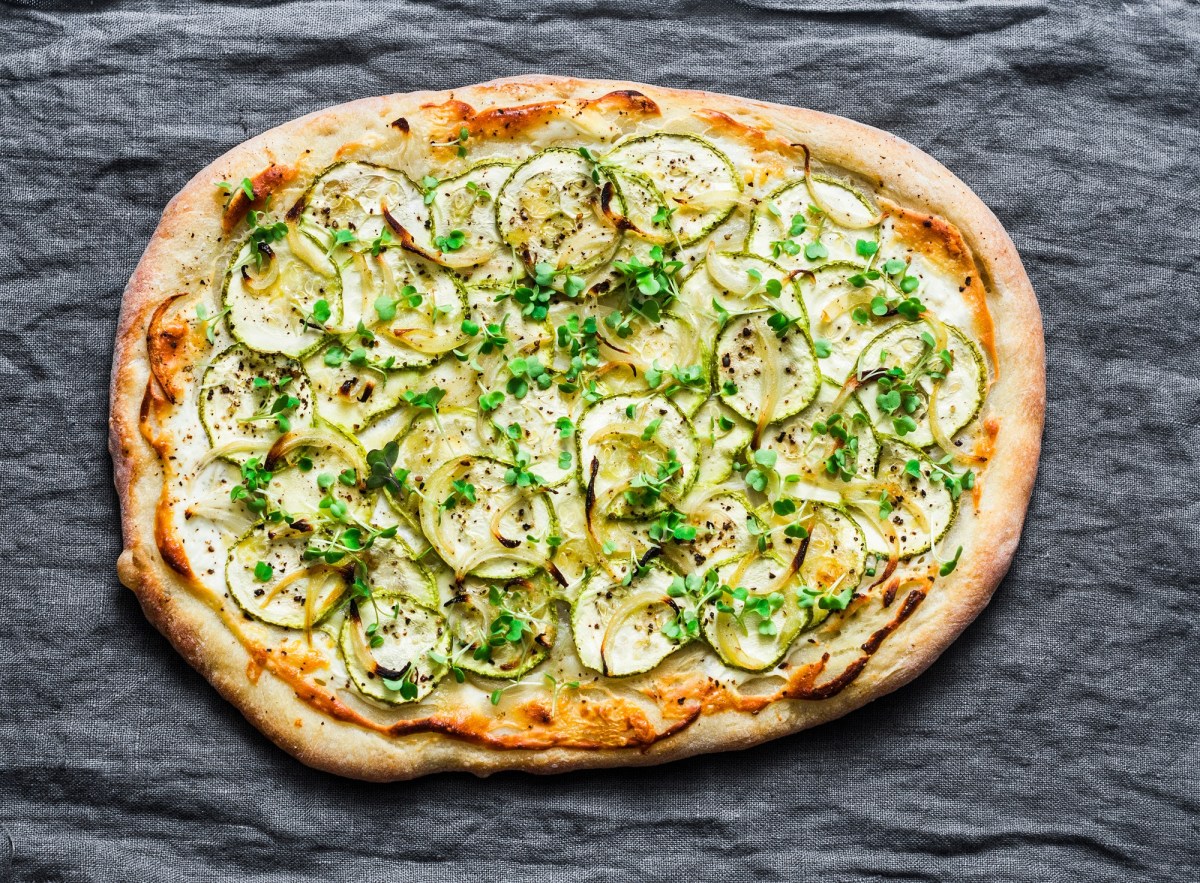 Eine Zucchini-Pizza auf einer Tischdecke.