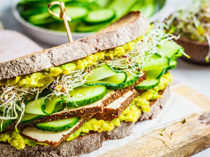 Ein Avocado-Tofu-Sandwich auf einem Brett