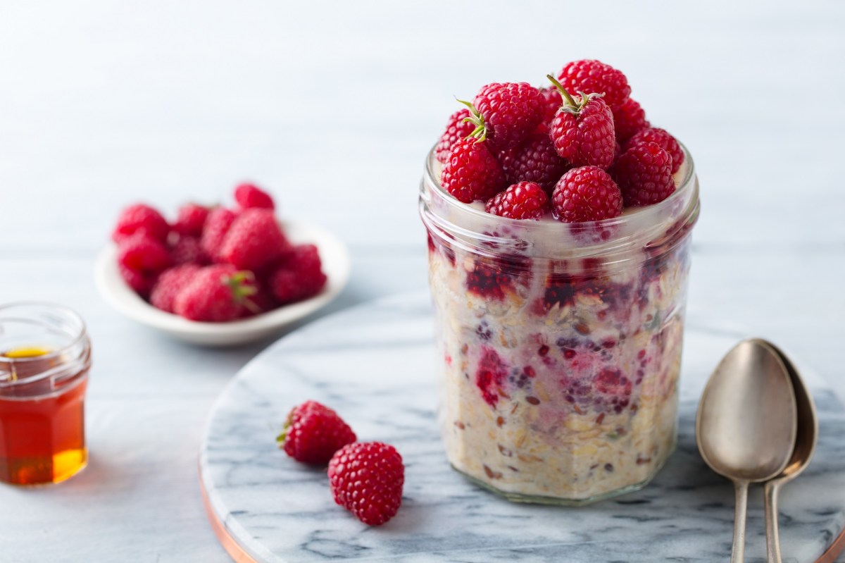 Bircher MÃ¼sli mit Himbeeren in einem Marmeladenglas.