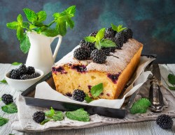 Brombeer-Joghurt-Kuchen auf einer Kuchenplatte, Minze