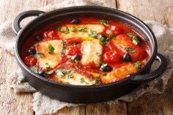 Eine Auflaufform mit Halloumi in Tomatensoße.