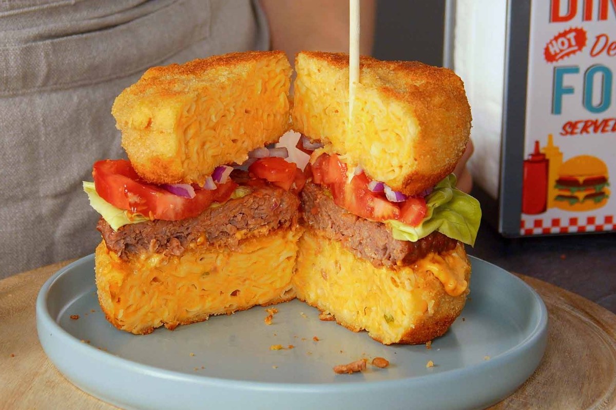 Ein aufgeschnittener Mac’n’Cheese-Burger auf einem Teller.