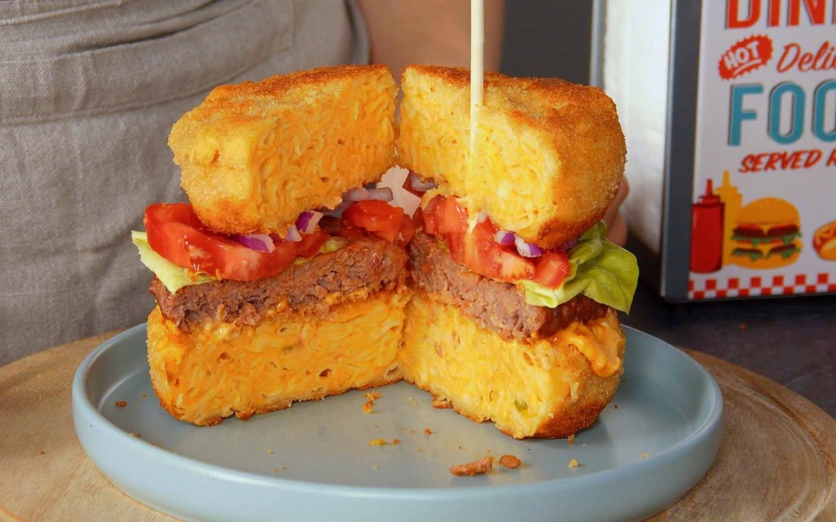 Ein aufgeschnittener Mac’n’Cheese-Burger auf einem Teller.