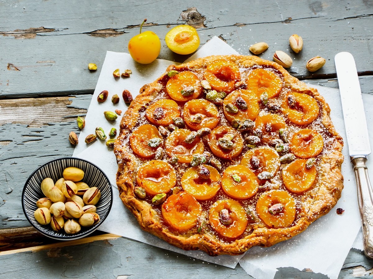 Pflaumen-Pistazien-Tarte auf einem Holztisch