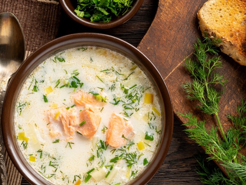 Eine Schüssel schwedische Sommersuppe in der Draufsicht. Daneben liegen frische Zutaten.