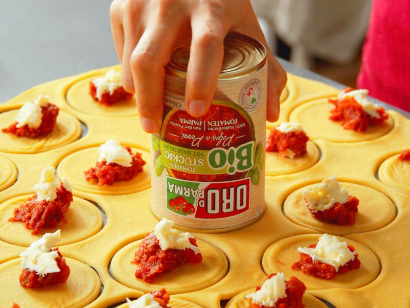 Tomaten-KÃ¤se-Ravioli mit Mozzarella und Salbeibutter: runde, mit Tomaten und Mozzarella bestÃ¼ckte Teiglinge.