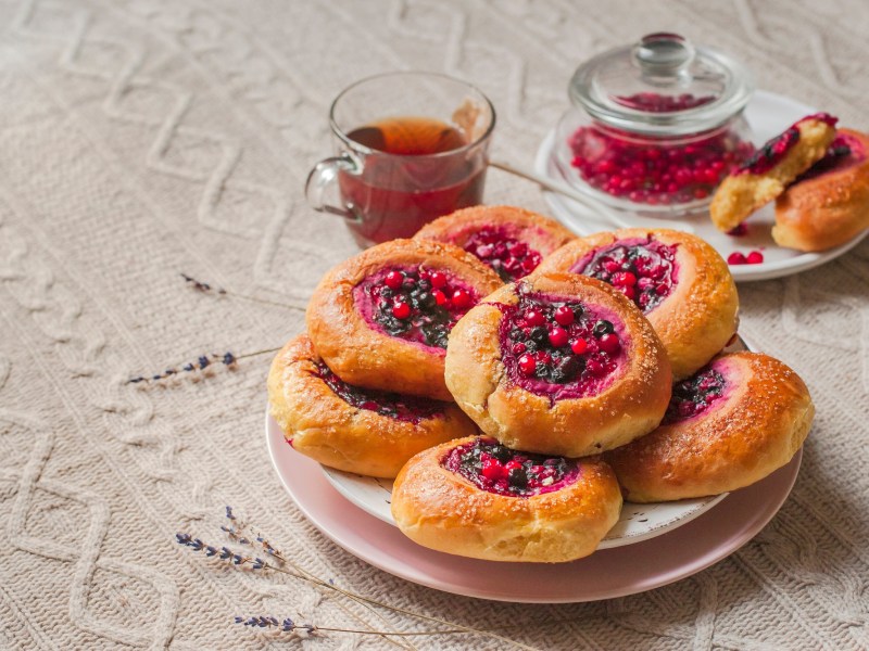 Cranberry-HefebrÃ¶tchen auf einem Teller.