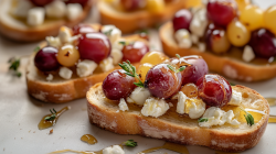 Mehrere Scheiben Feta-Trauben-Bruschetta mit Thymian und Honig.