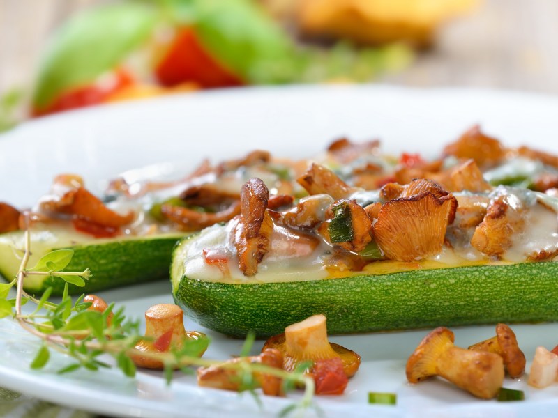 GefÃ¼llte Zucchini mit Pfifferlingen auf einem Teller. Nahaufnahme.