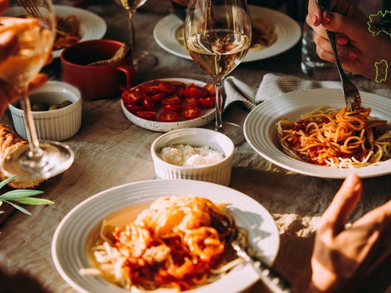 Italienische KÃ¼che: Eine Gruppe Menschen an einem Tisch mit italienischem Essen.