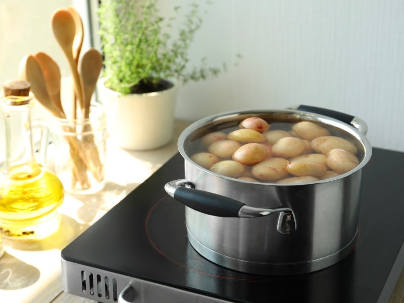 Kartoffeln mit kaltem Wasser ansetzen: Ein Topf Kartoffeln auf einer Induktionsplatte.