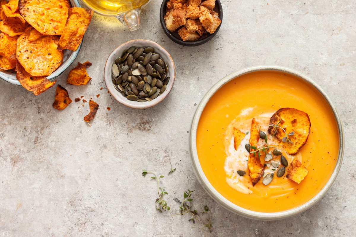 Schale mit KÃ¼rbis-SÃ¼ÃŸkartoffel-Suppe, KÃ¼rbiskernen und SÃ¼ÃŸkartoffelchips