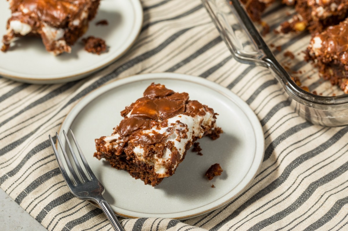 Ein StÃ¼ck Mississippi Mud Cake auf einem weiÃŸen Teller. Daneben steht der Rest des Kuchens.