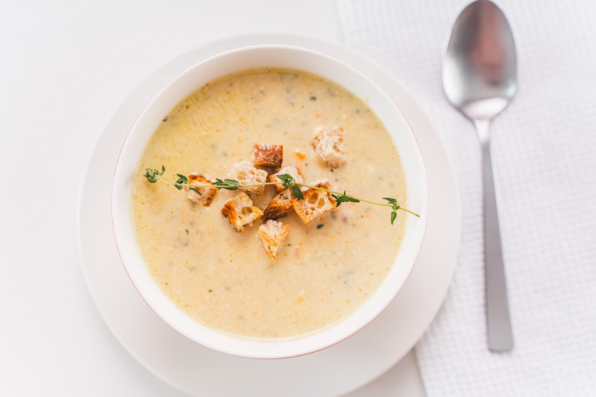 SchÃ¼ssel mit Parmesan-Suppe und LÃ¶ffel