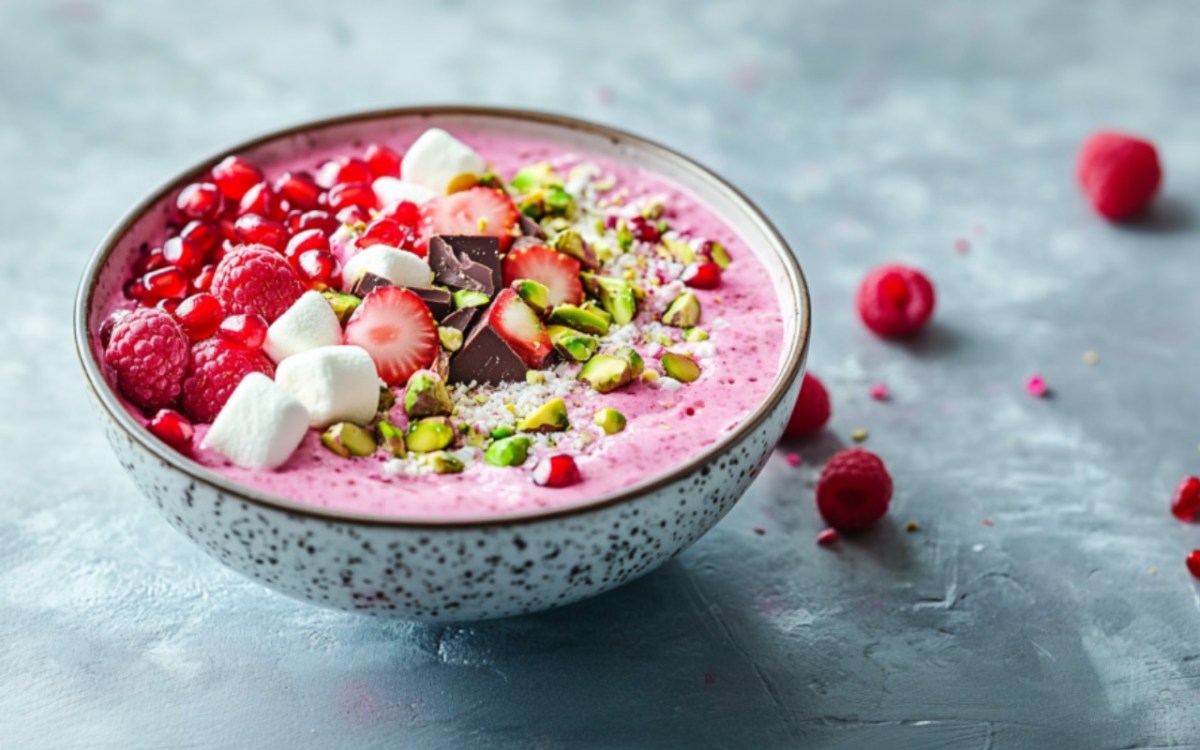 Eine SchÃ¼ssel Pink Porridge mit Toppings.