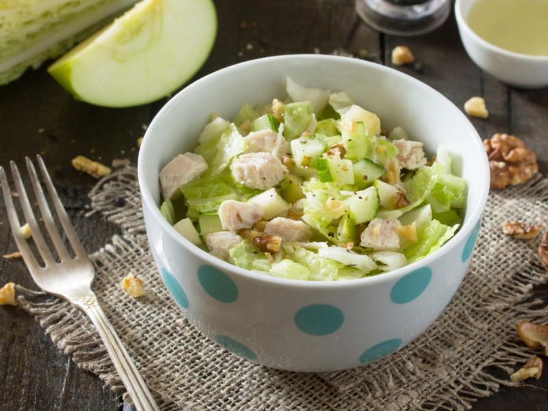 Eine SchÃ¼ssel Apfelsalat mit HÃ¼hnchen.