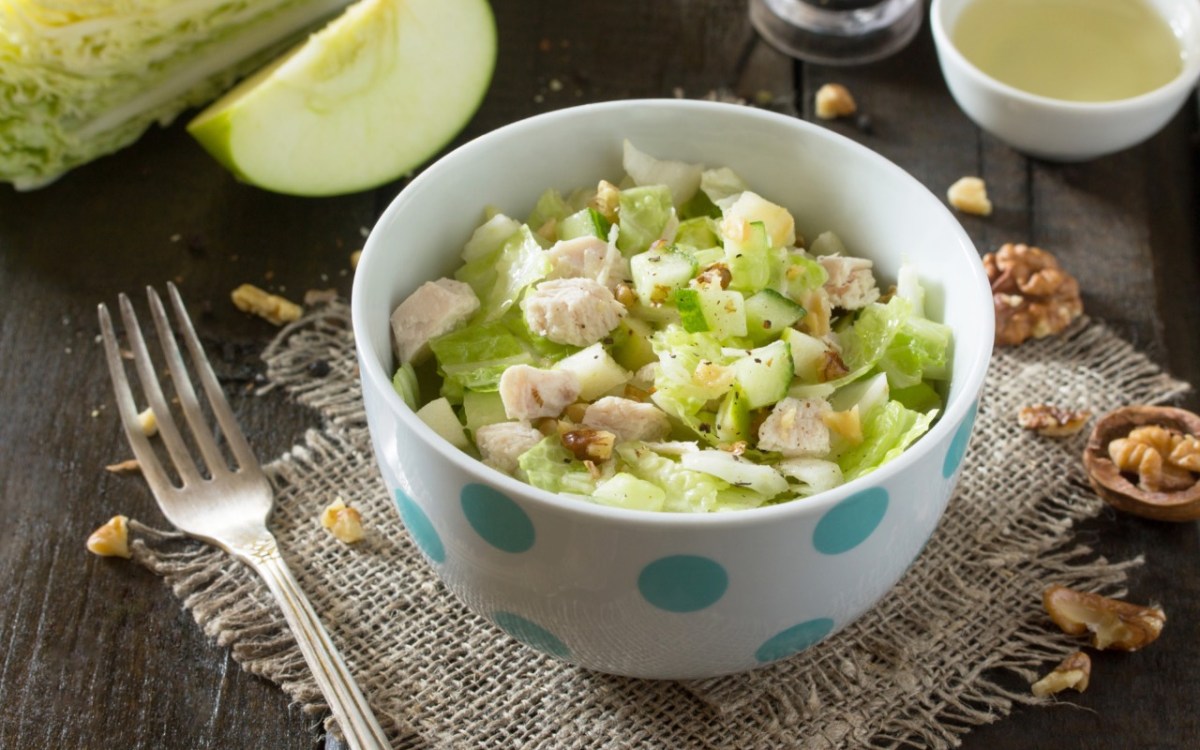 Eine SchÃ¼ssel Apfelsalat mit HÃ¼hnchen.