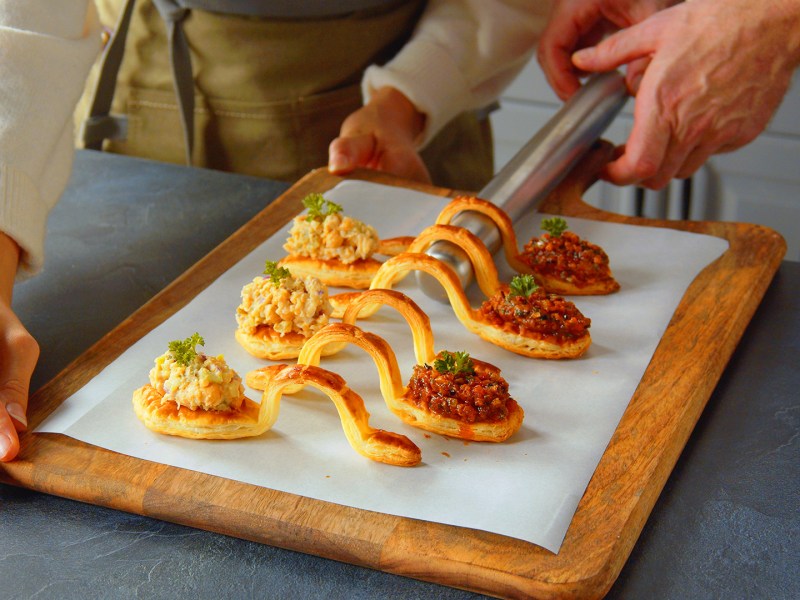 BlÃ¤tterteig-LÃ¶ffel mit Kichererbsensalat und frittiertem GemÃ¼se aus einem Brett.