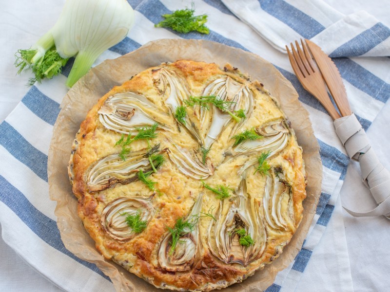 Fenchel-Quiche auf einem gestreiften Geschirrtuch.