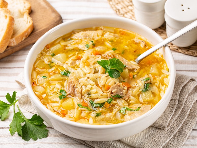 HÃ¼hnersuppe mit Orzo in einer SchÃ¼ssel.