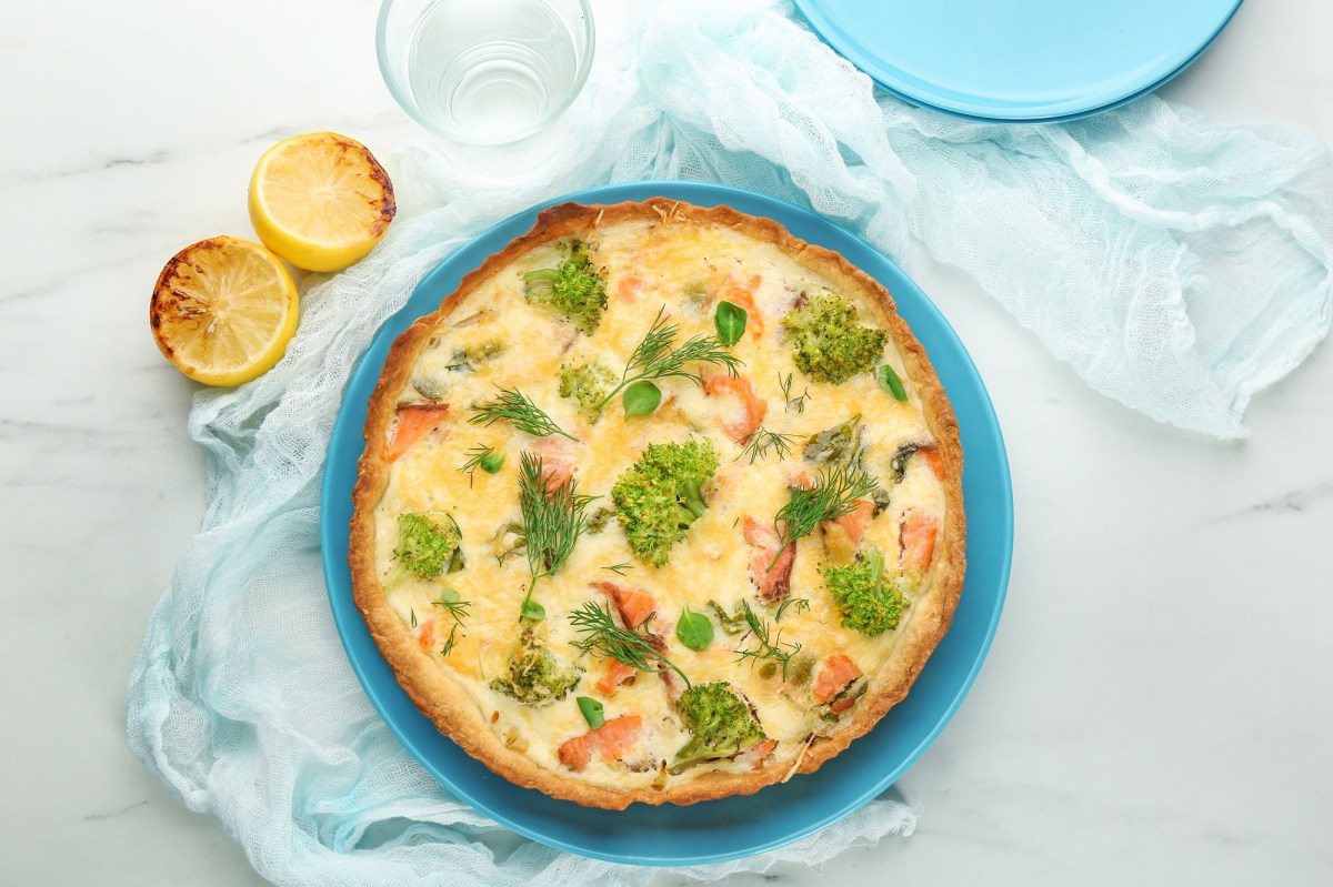 Lachs-Brokkoli-Quiche auf einem blauen Teller.