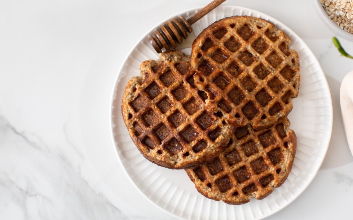 Drei Apfel-Müsli-Waffeln auf einem Teller in der Draufsicht.