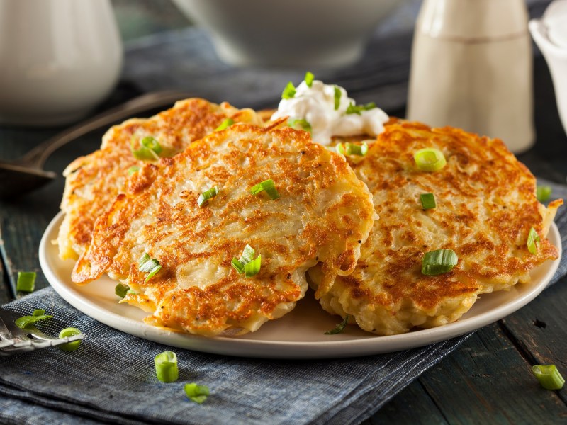 Boxty: irische Kartoffelpuffer auf einem Teller, bestreut mit Frühlingszwiebeln.