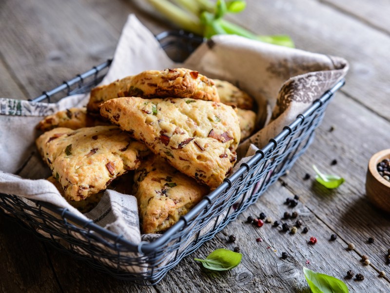 Cheddar-Bacon-Scones in einem schwarzen Brotkorb.