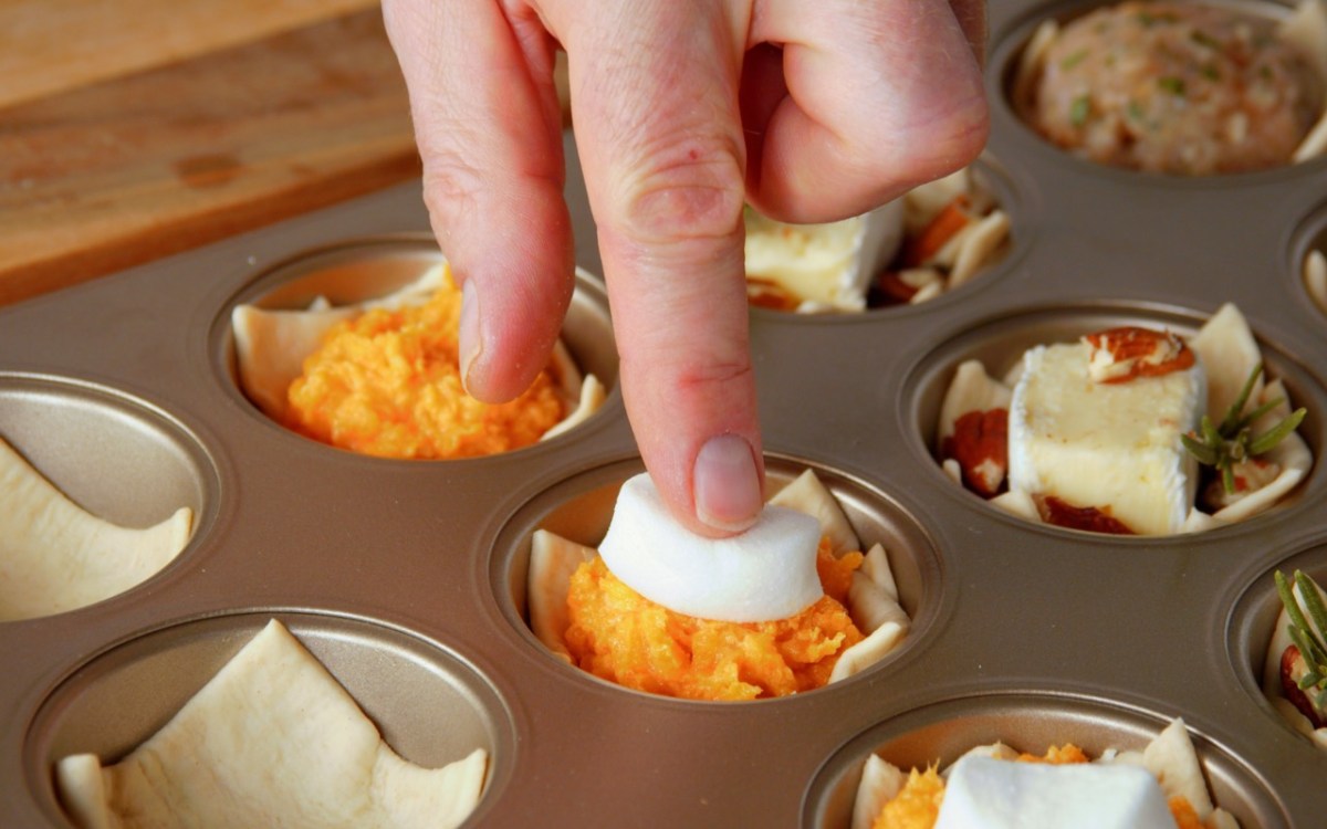 Fingerfood-Cups: Ein Marshmallow wird auf Kartoffelbrei aus SÃ¼ÃŸkartoffel in einem Muffinblech gedrÃ¼ckt.