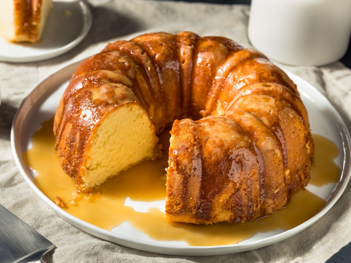 Karibischer Rumkuchen auf einem weißen Teller. Dazu Rum-Butter-Sirup.