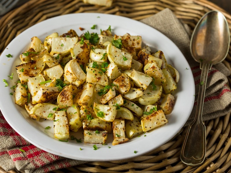 Ein Teller mit Kohlrabi aus der HeiÃŸluftfritteuse, garniert mit Petersilie.