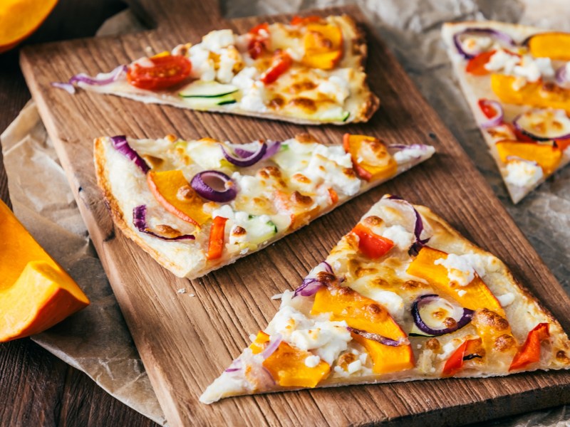 Brett mit drei StÃ¼cken KÃ¼rbis-Flammkuchen mit Feta